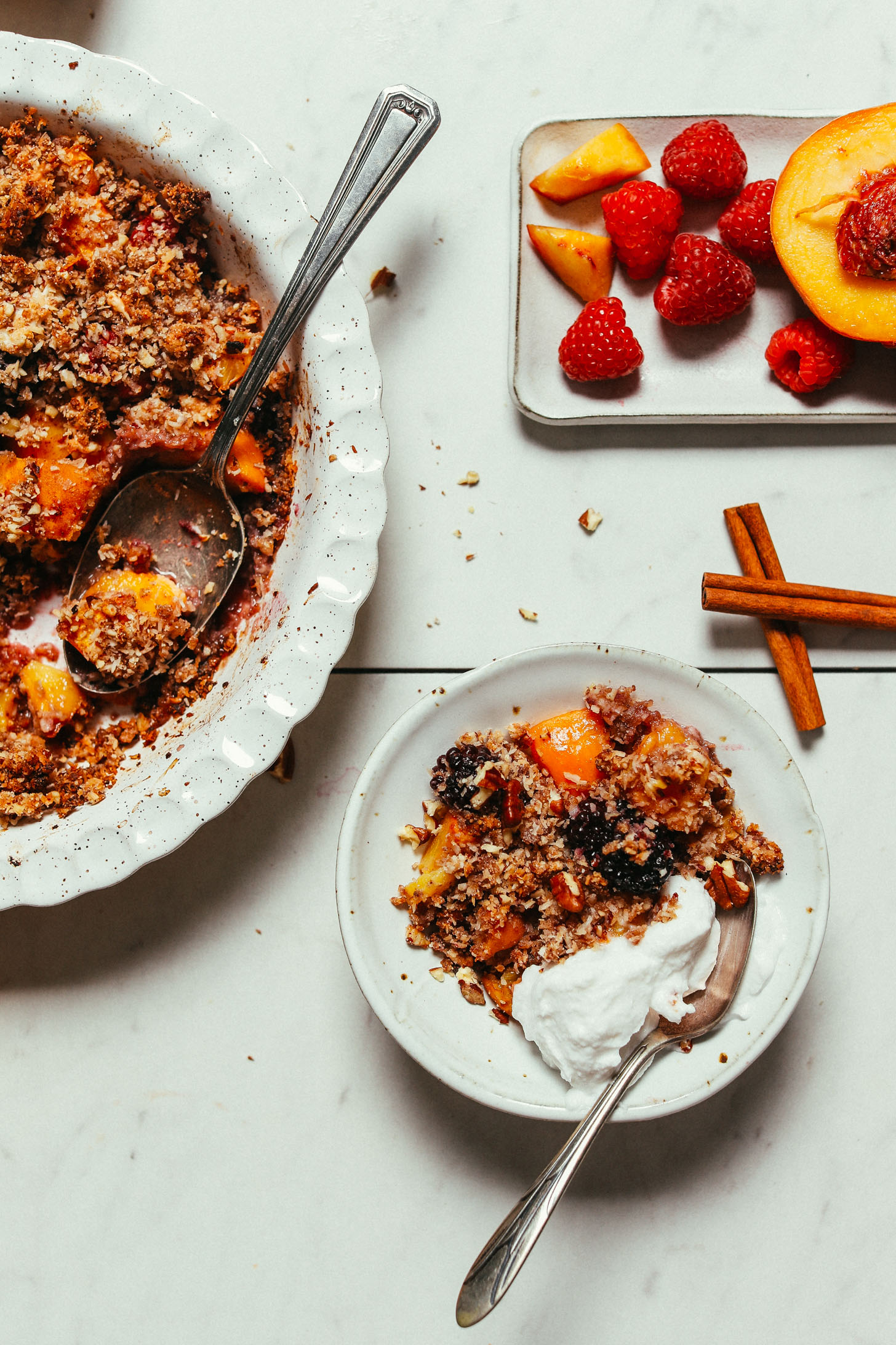 Pie pan and bowl of Raw Fruit Crisp served with coconut yogurt