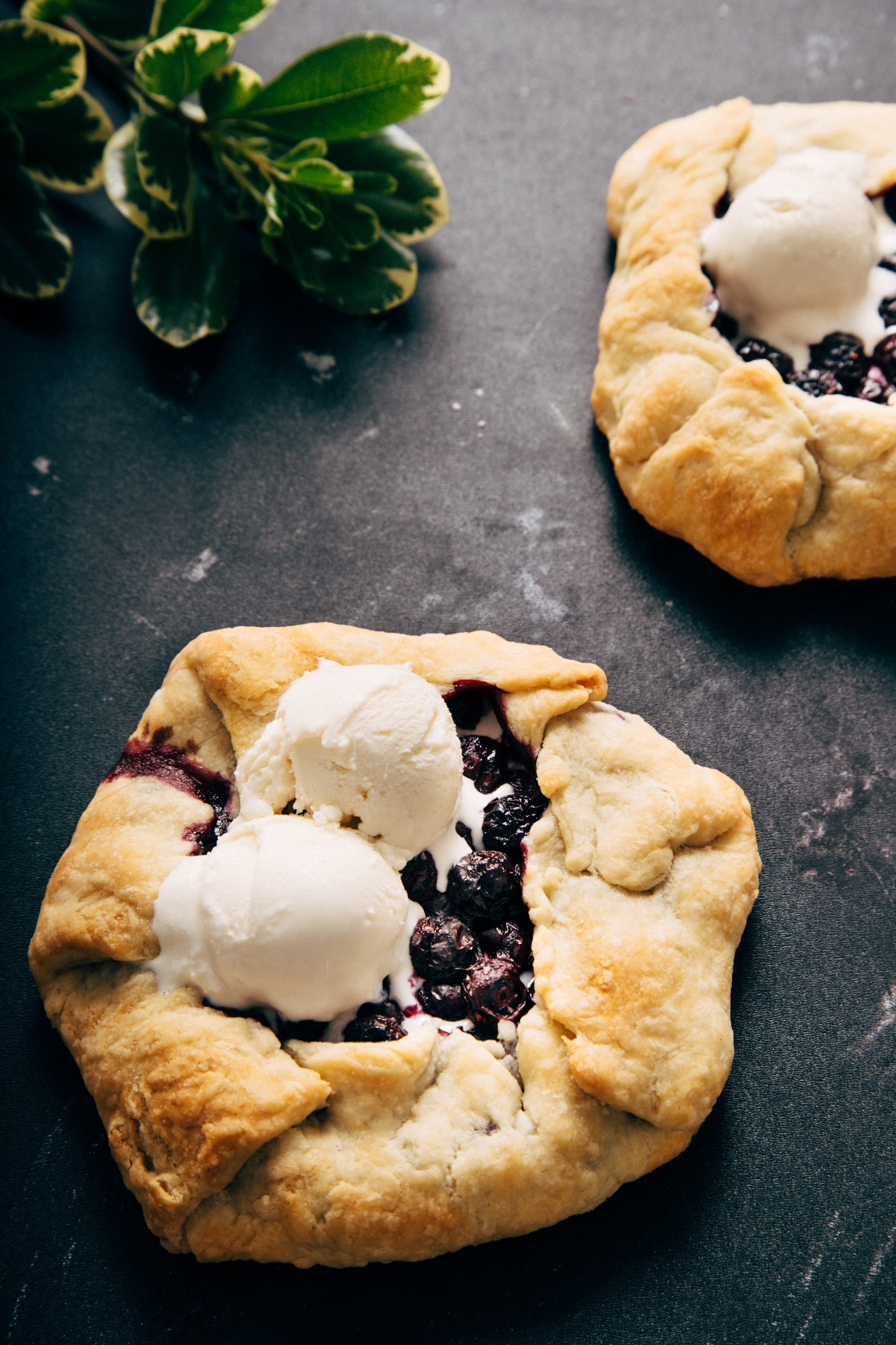 Two Mini Blueberry Galettes topped with scoops of vanilla ice cream