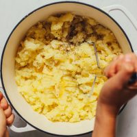 Using a potato masher to show How to Make Mashed Potatoes