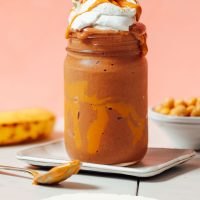 Jar of our Peanut Butter Chocolate Chickpea Shake topped with coconut whipped cream