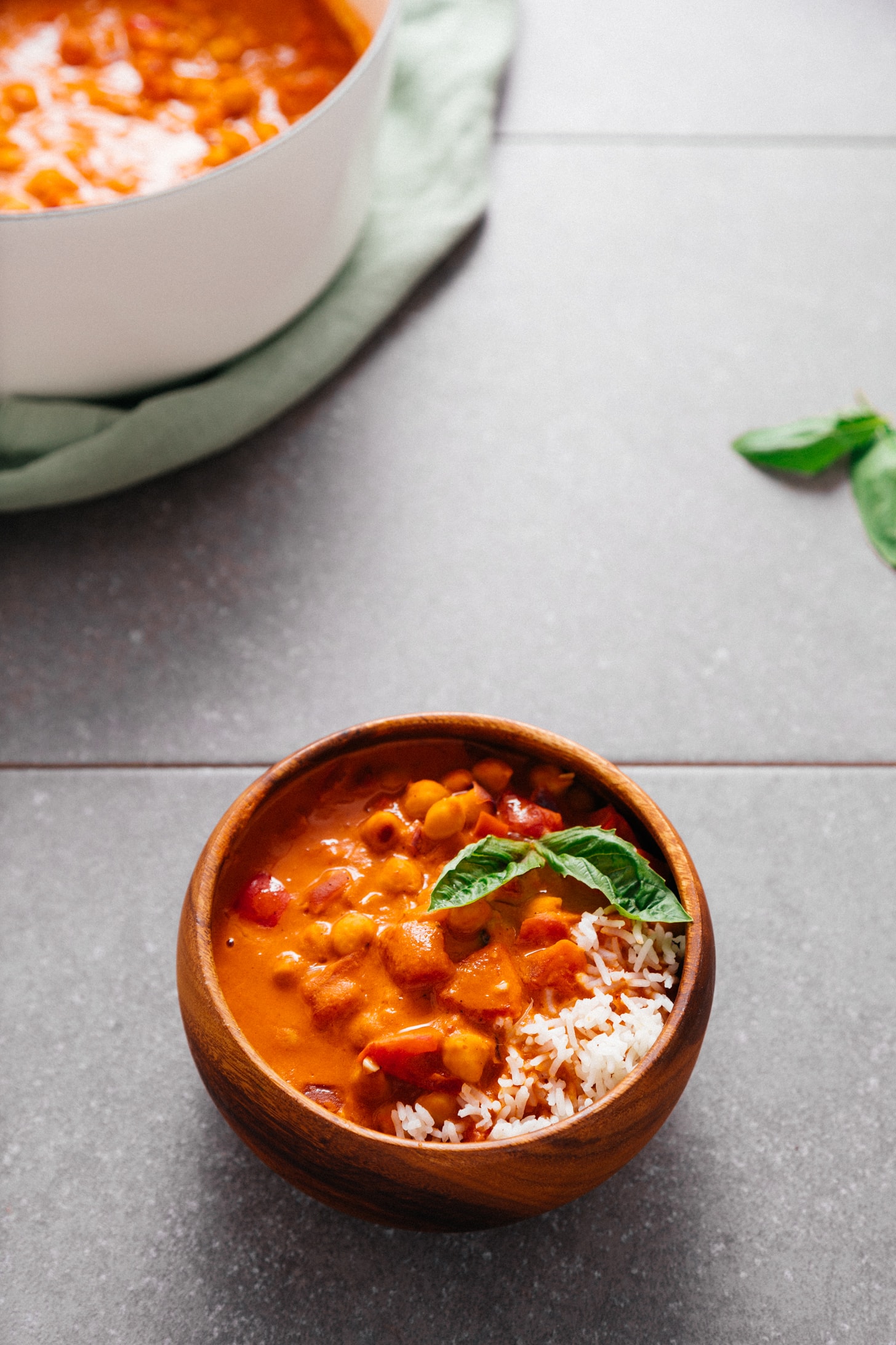 Bowl of West African-Inspired Chickpea Tomato Peanut Stew with rice and fresh basil