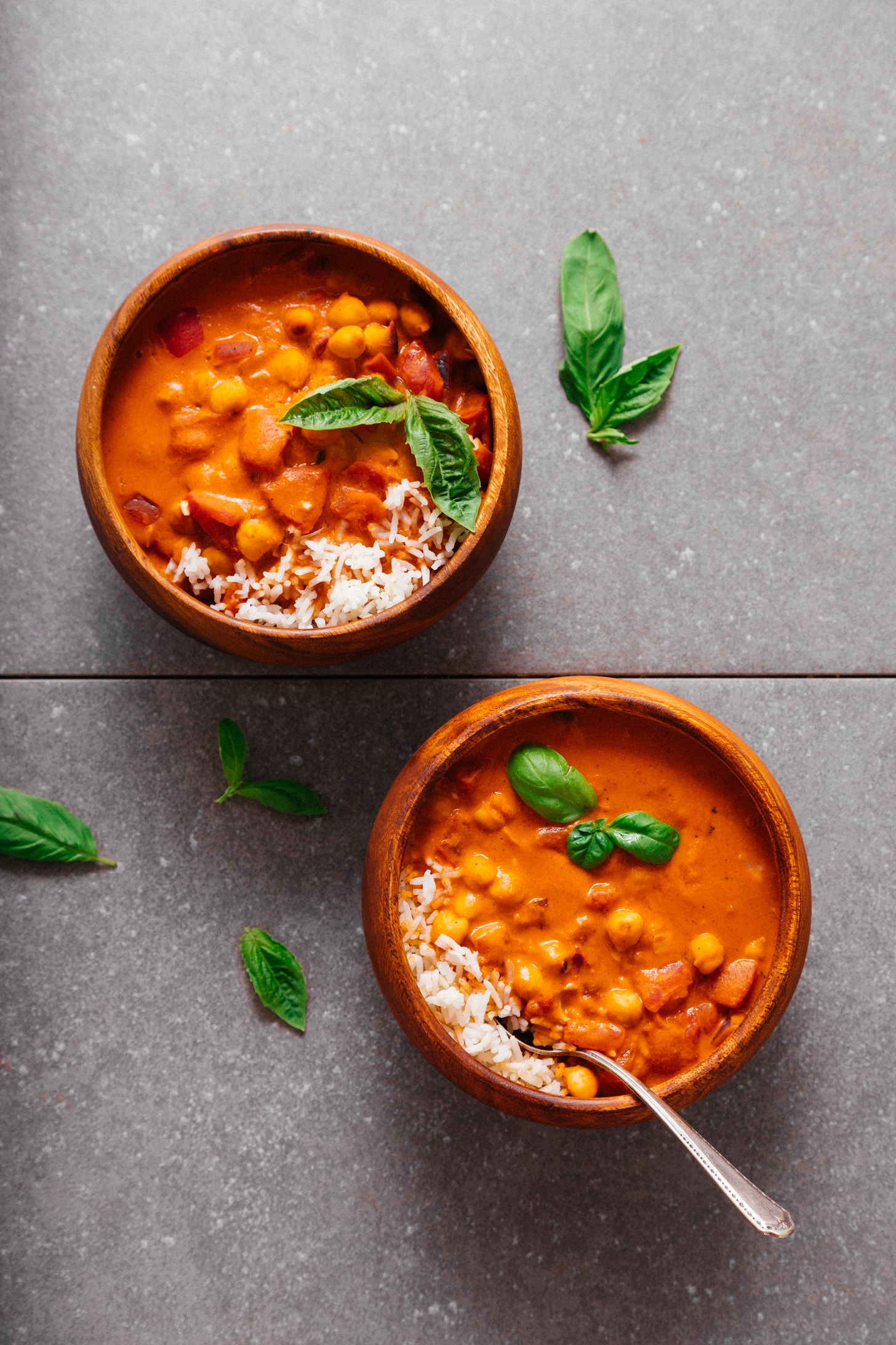 Two bowls of rice beside our Creamy Chickpea Tomato Peanut Stew recipe