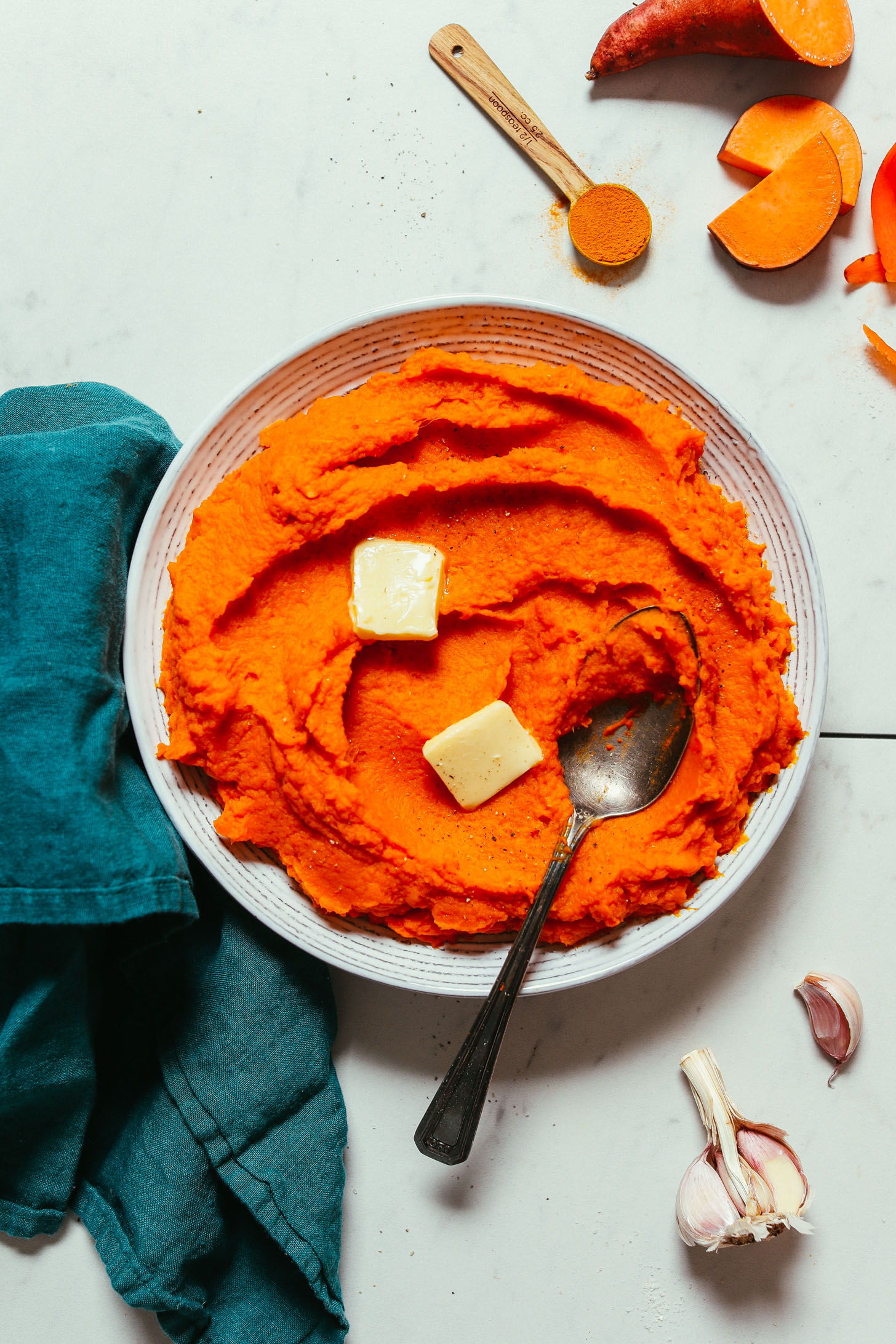Bowl of Vegan Mashed Sweet Potatoes and Carrots topped with slices of dairy-free butter