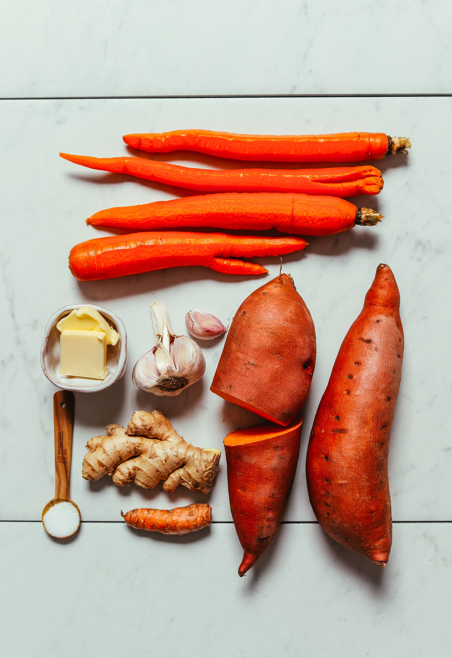 Carrots, sweet potatoes, ginger, garlic, turmeric, vegan butter, and sea salt for making Vegan Mashed Sweet Potatoes and Carrots