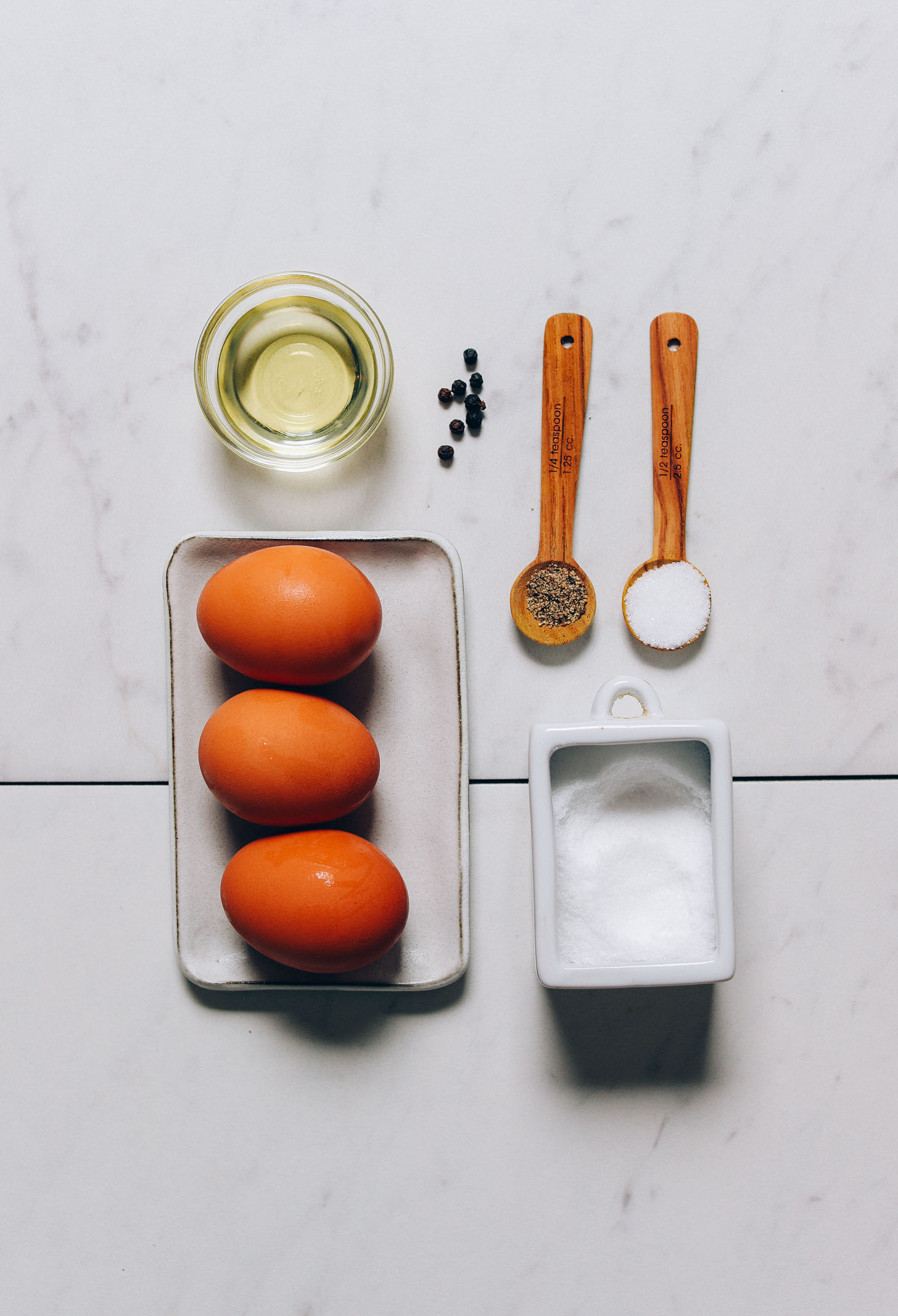 Salt, pepper, eggs, and avocado oil for making our Perfect Fried Eggs recipe