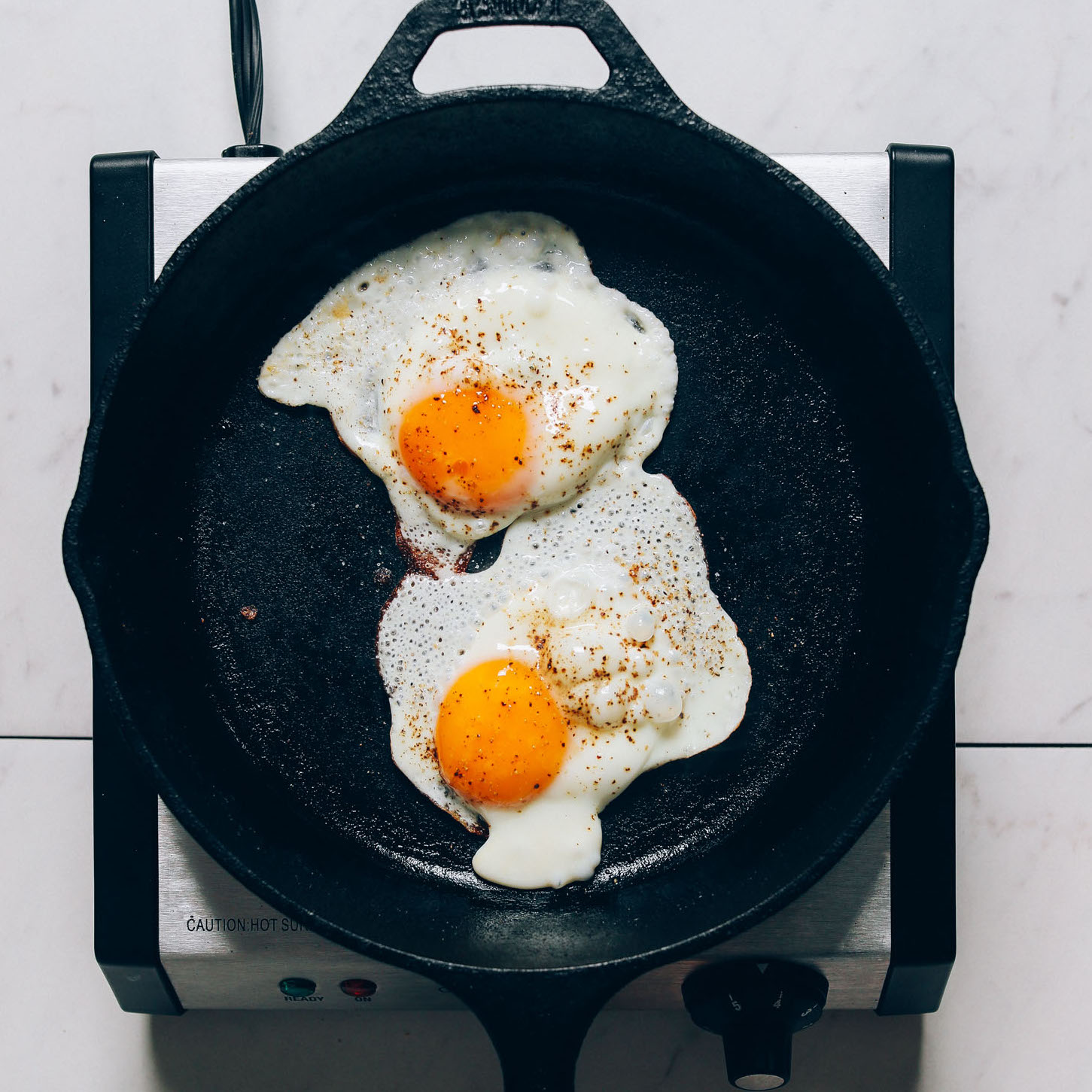 Eggs in a skillet for our tutorial on How to Fry an Egg