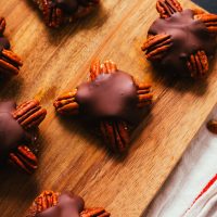 Delicious homemade Vegan Chocolate Turtle Candies on a wood cutting board