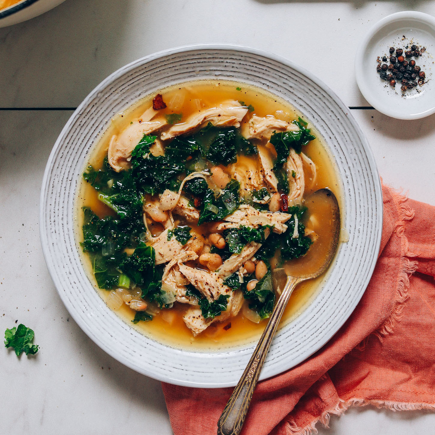 Spoon resting in a bowl of Kale White Bean Chicken Soup