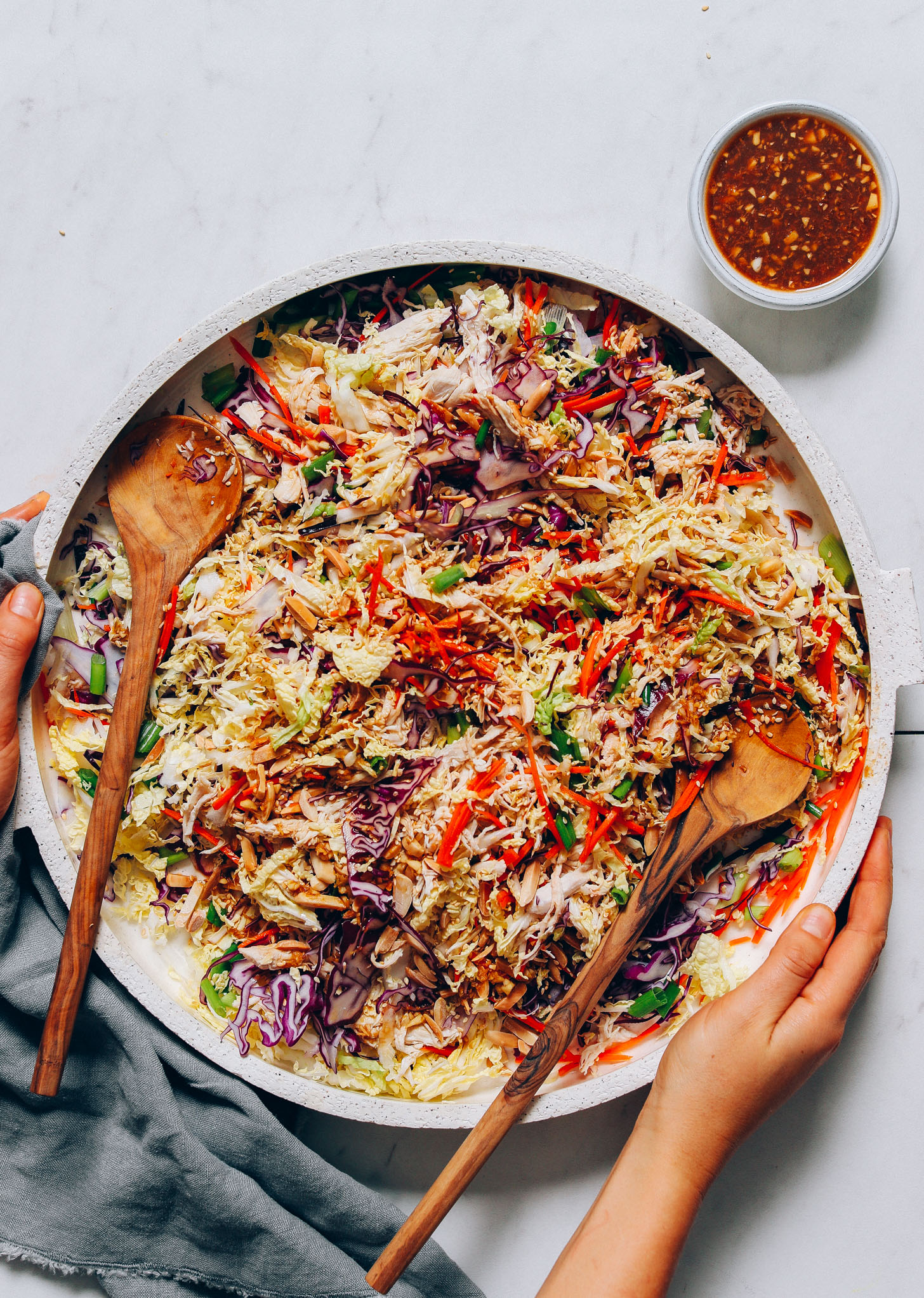 Platter of Crunchy Cabbage Slaw beside a bowl of gluten-free and soy-free dressing