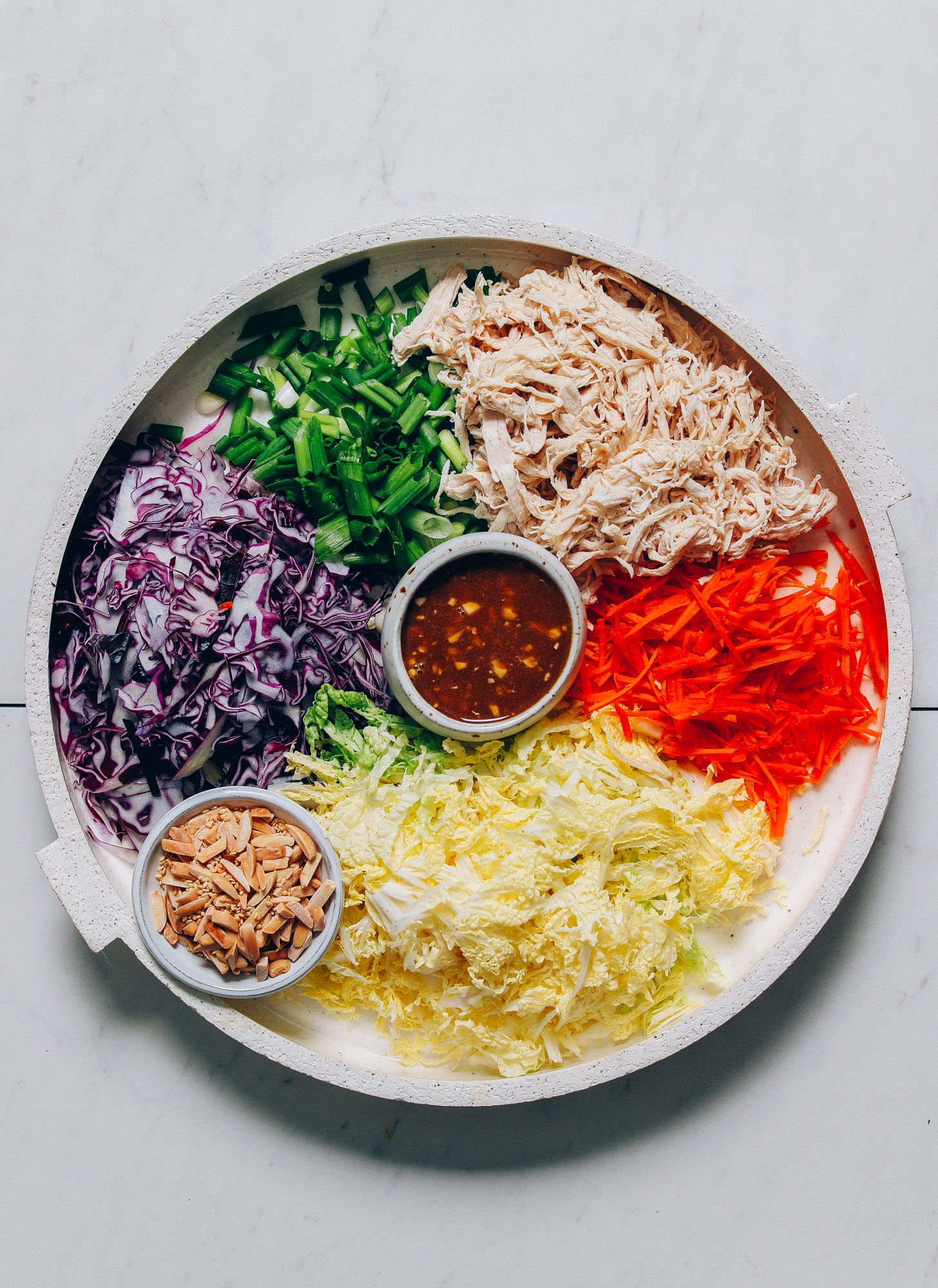 Tray filled with fresh vegetables and chicken for making our easy Crunchy Cabbage Slaw with Sesame Ginger Dressing