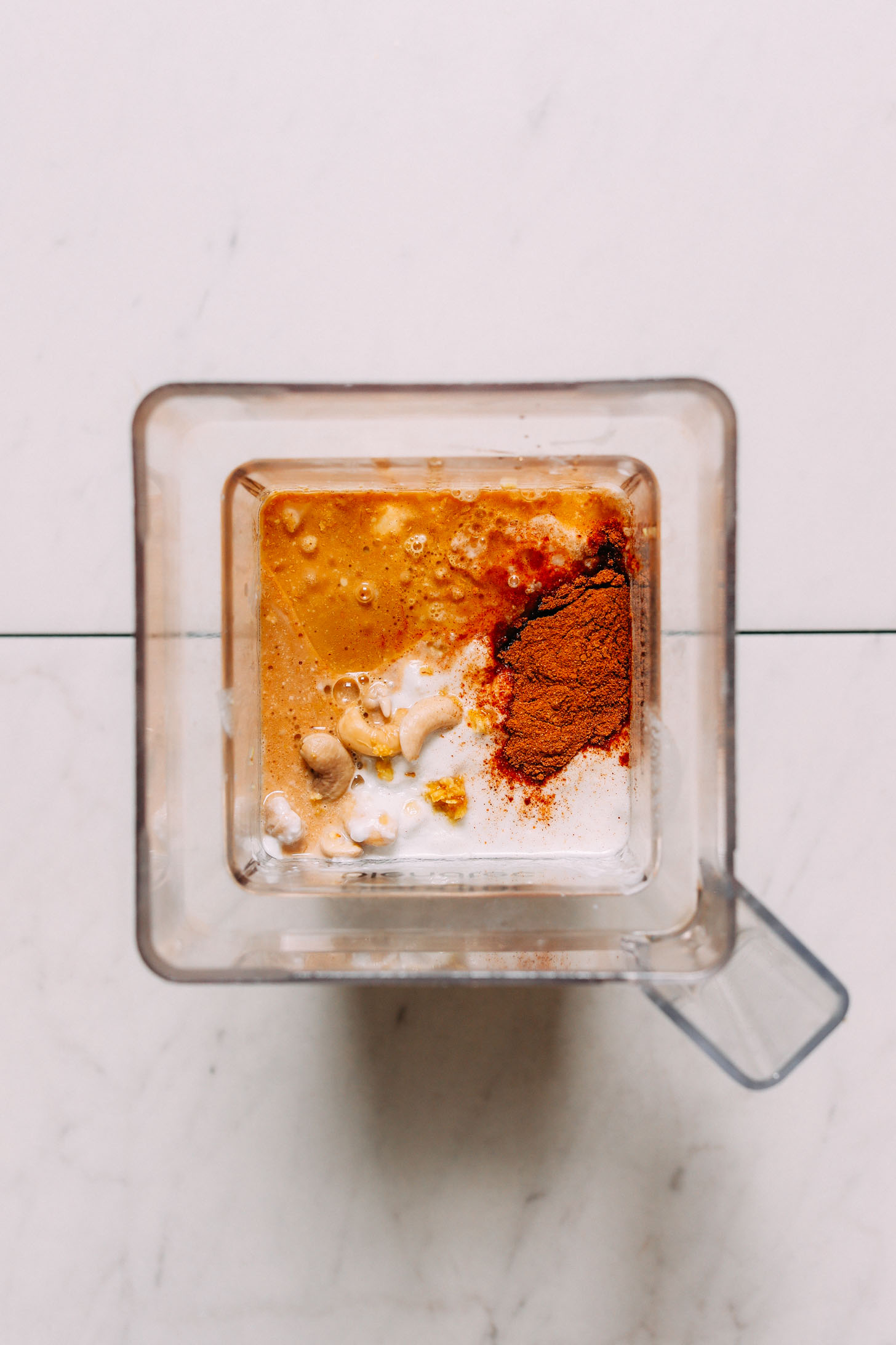 overhead image of vegan chai cheesecake ingredients in a square blender