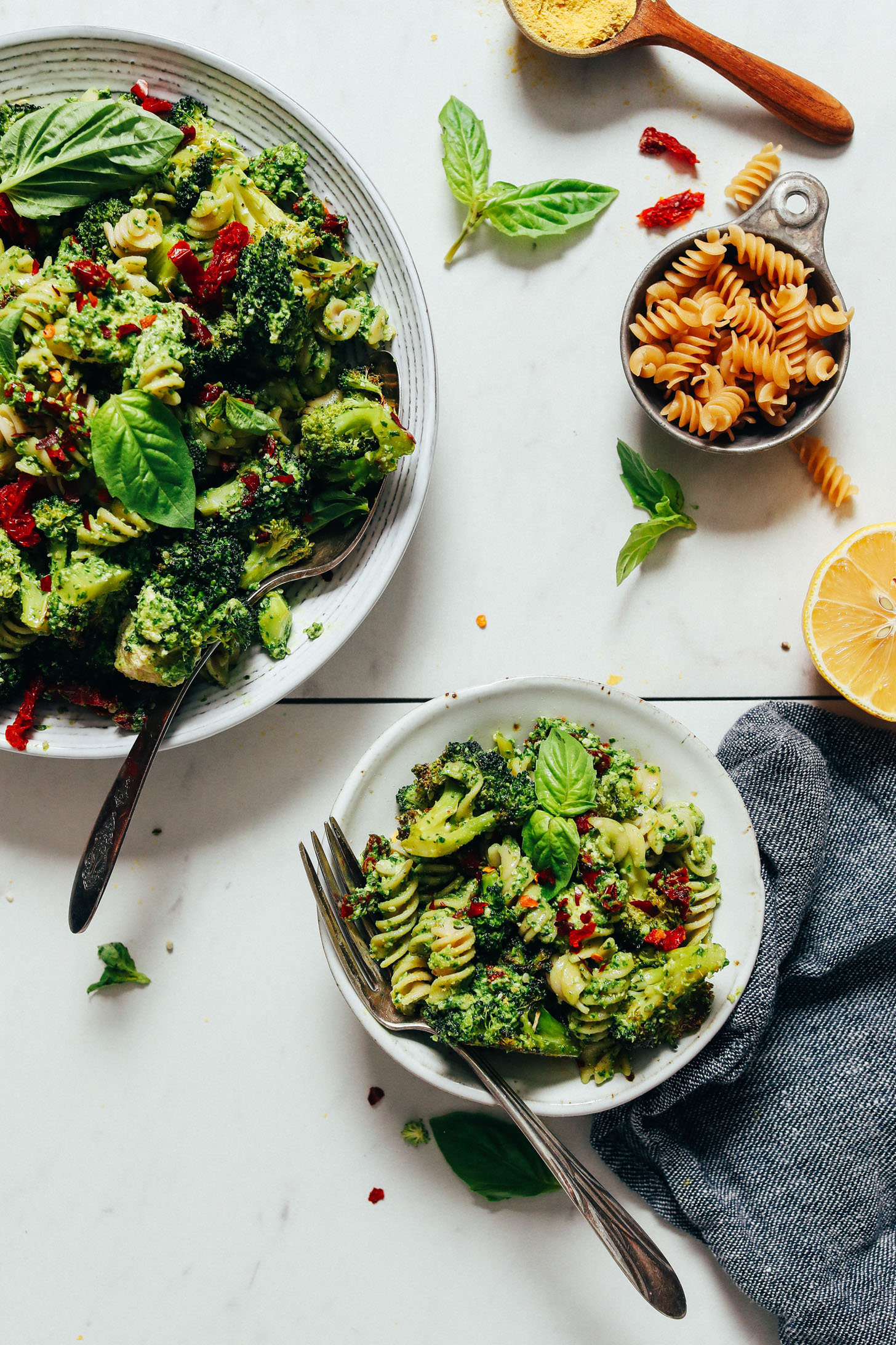 Small and large bowls of our Pesto Broccoli Pasta Salad with Sun-dried Tomatoes