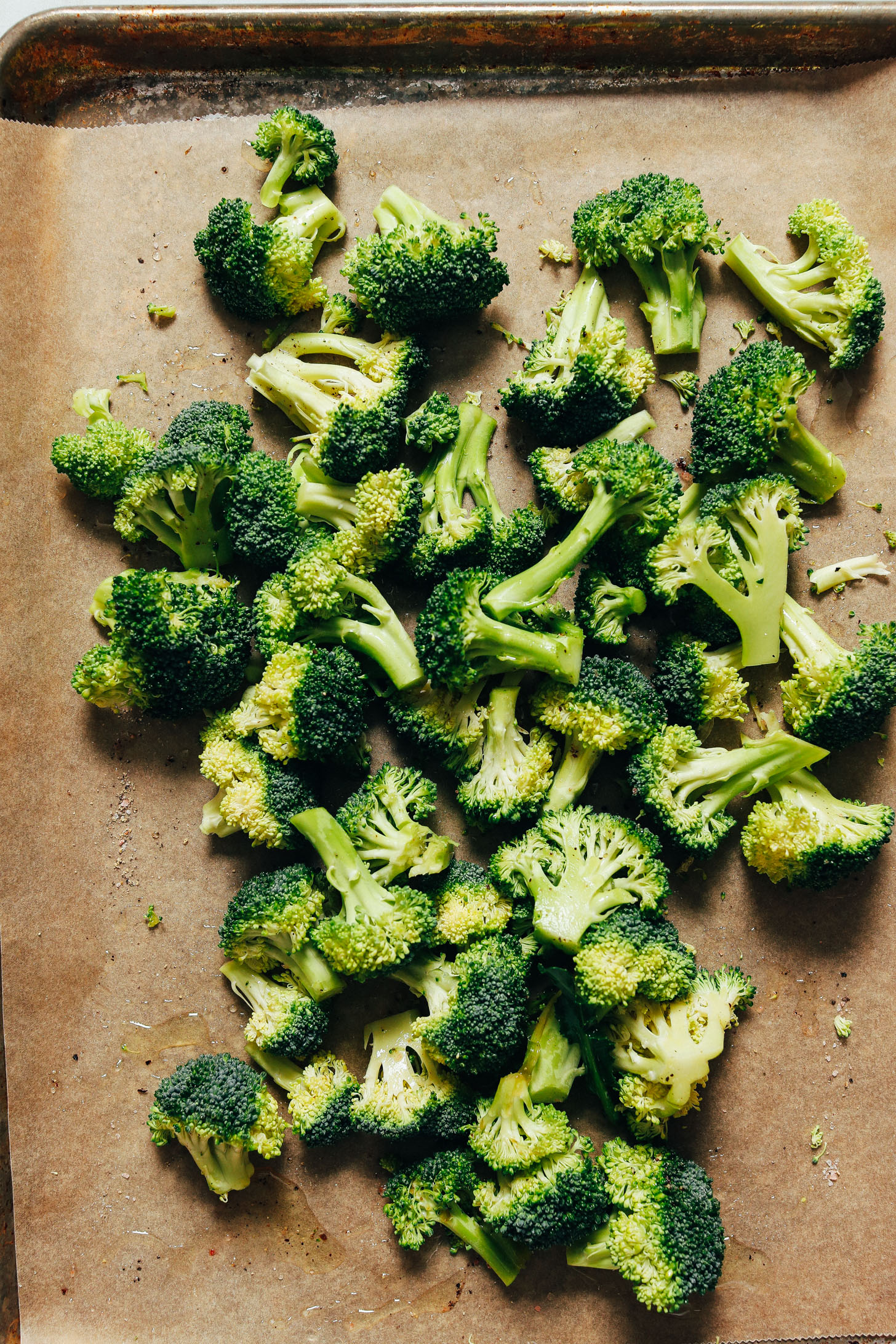 Broccoli on a parchment-lined baking sheet for making our Roasted Broccoli & Pesto Pasta Salad recipe