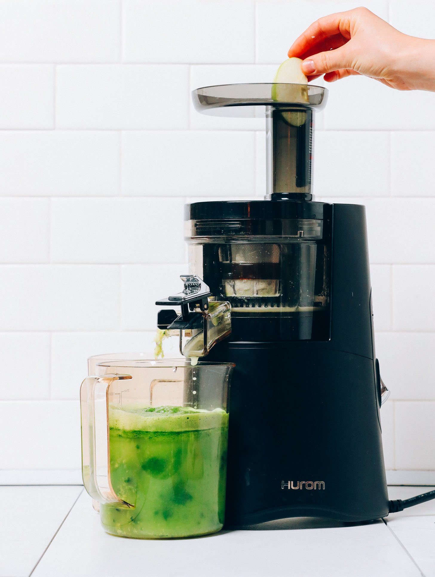 Adding apple to a Hurom juicer to make our Easy Green Juice recipe