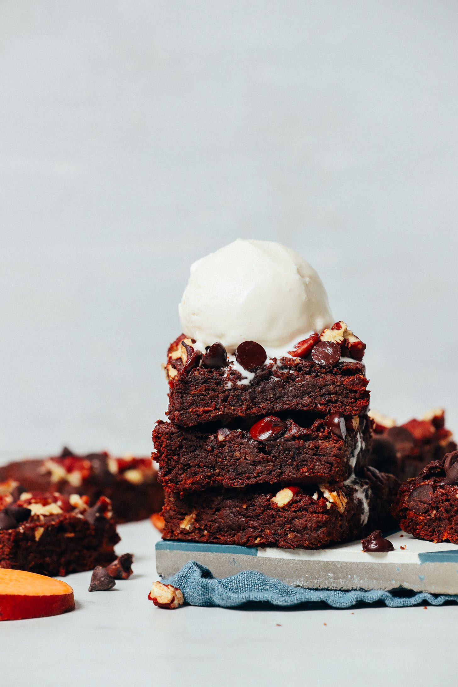 A stack of sweet potato brownies topped with vegan vanilla ice cream