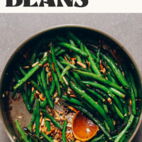 Sautéing green beans in a skillet with garlic and slivered almonds