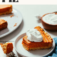 Slice of vegan gluten-free pumpkin pie with a bite next to it on a fork