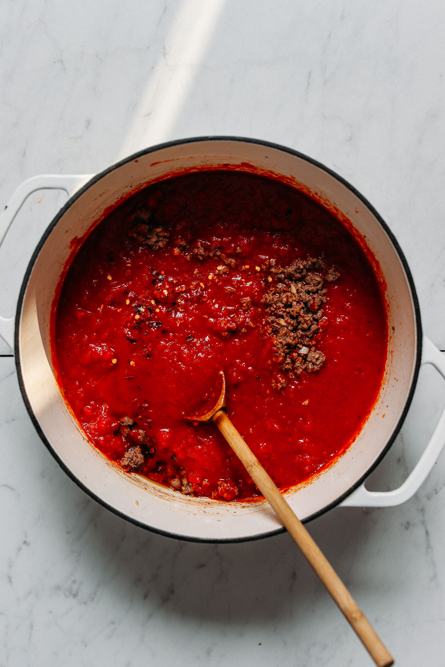 Dutch oven filled with our ground beef marinara sauce for making Dairy-Free Gluten-Free Lasagna