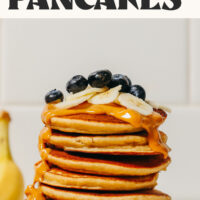 Stack of our easy gluten-free blender banana pancakes topped with sliced banana and blueberries