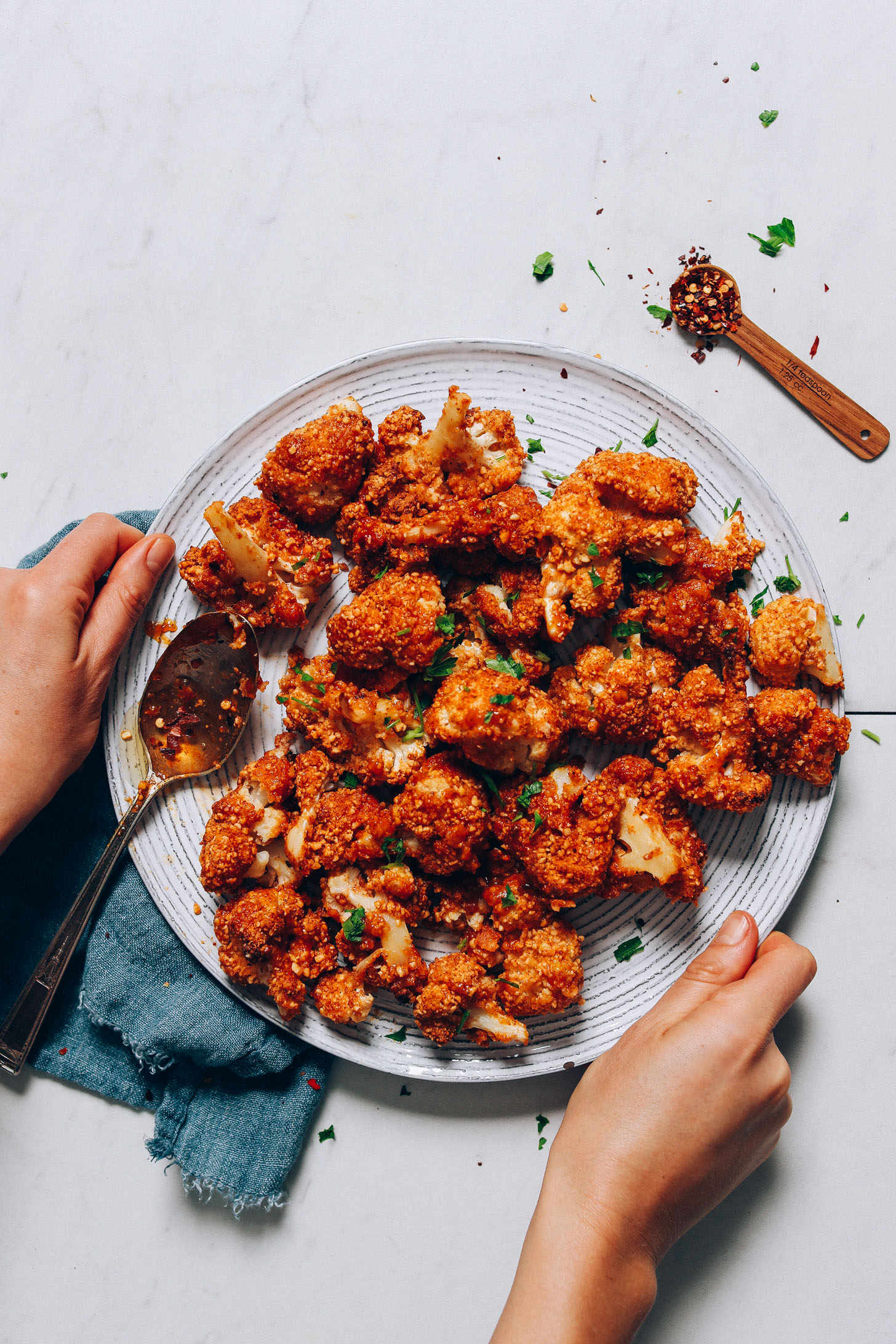 Holding the sides of a plate of Crispy Breaded Cauliflower