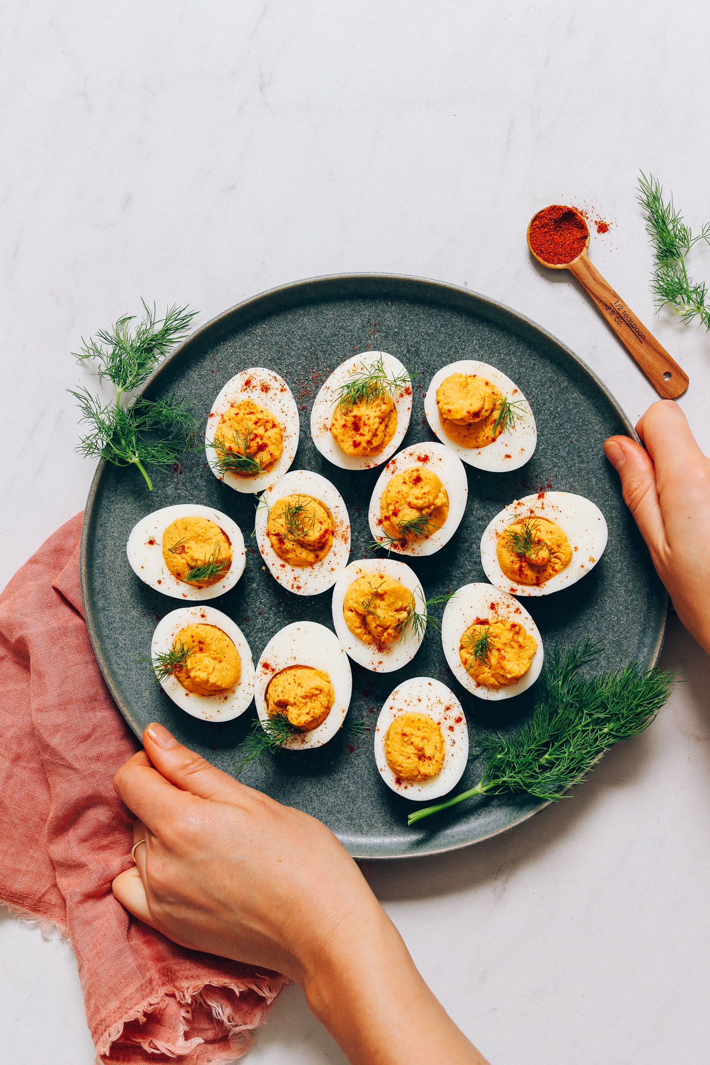 Holding the sides of a plate of Mayo-Free Deviled Eggs