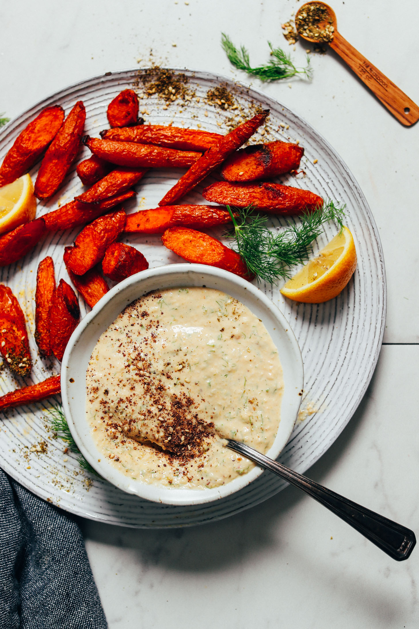 Plate with roasted carrots and a bowl of our easy Dill Garlic Sauce recipe