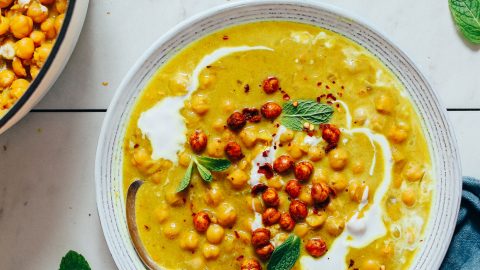 Spoon resting in a bowl of Curried Chickpea Soup topped with fresh cilantro
