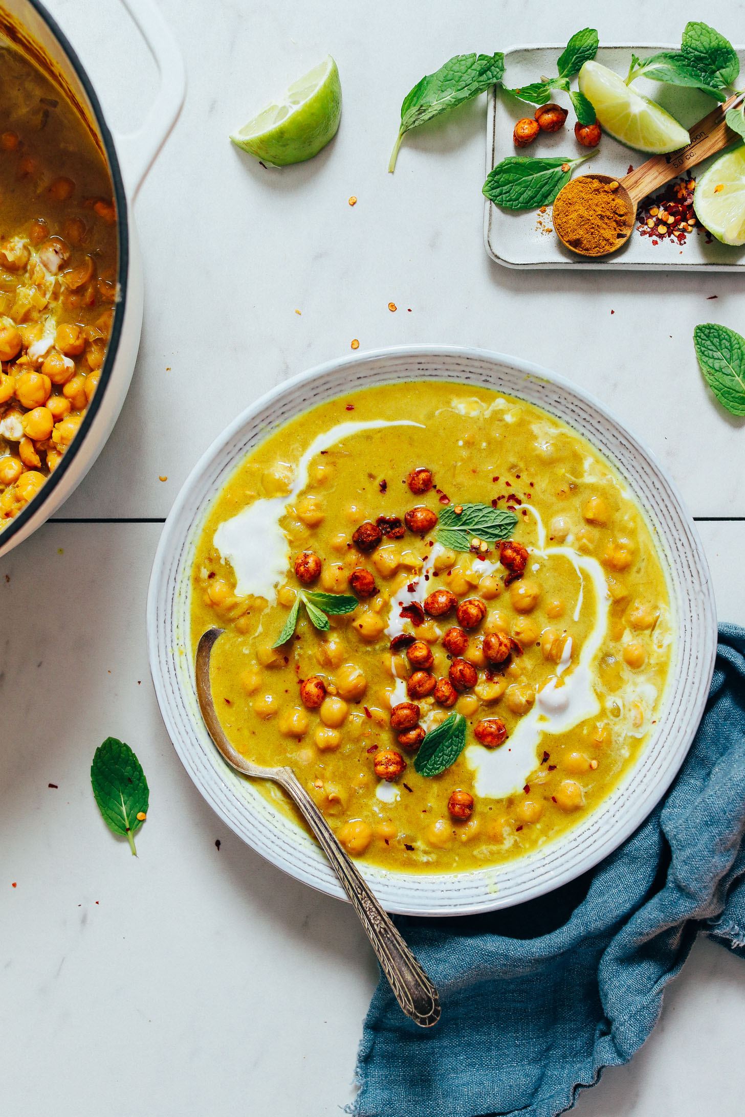 Spoon resting in a bowl of Curried Chickpea Soup topped with fresh cilantro