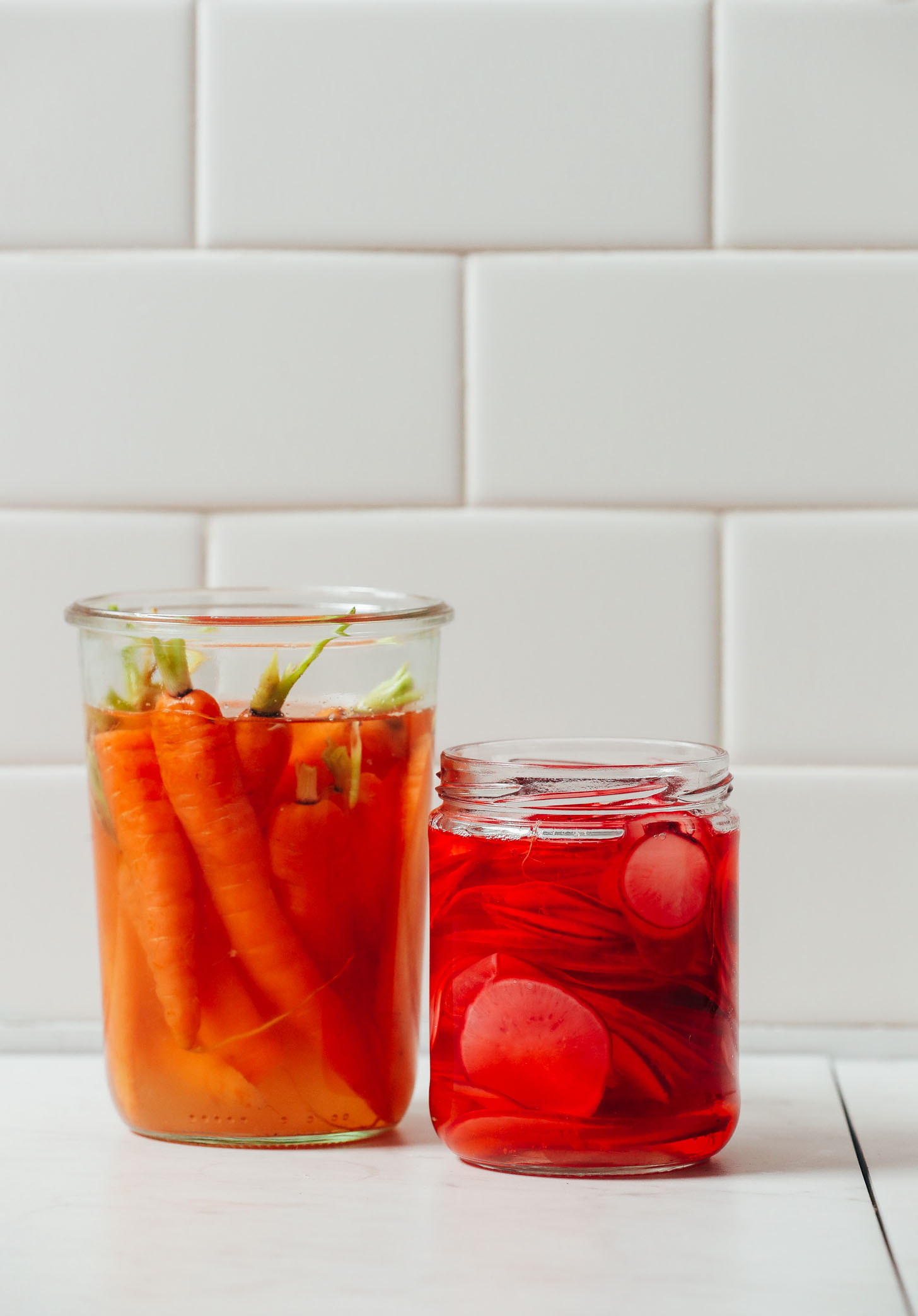 Jar of Quick Pickled Carrots next to a jar of Quick Pickled Radish