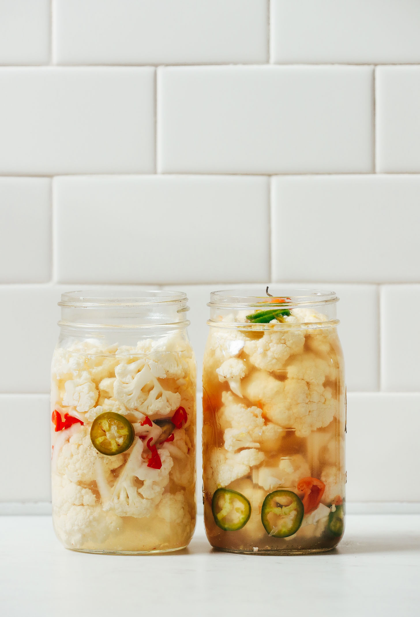 Sliced spicy peppers in a jar with Pickled Cauliflower to make Escabeche