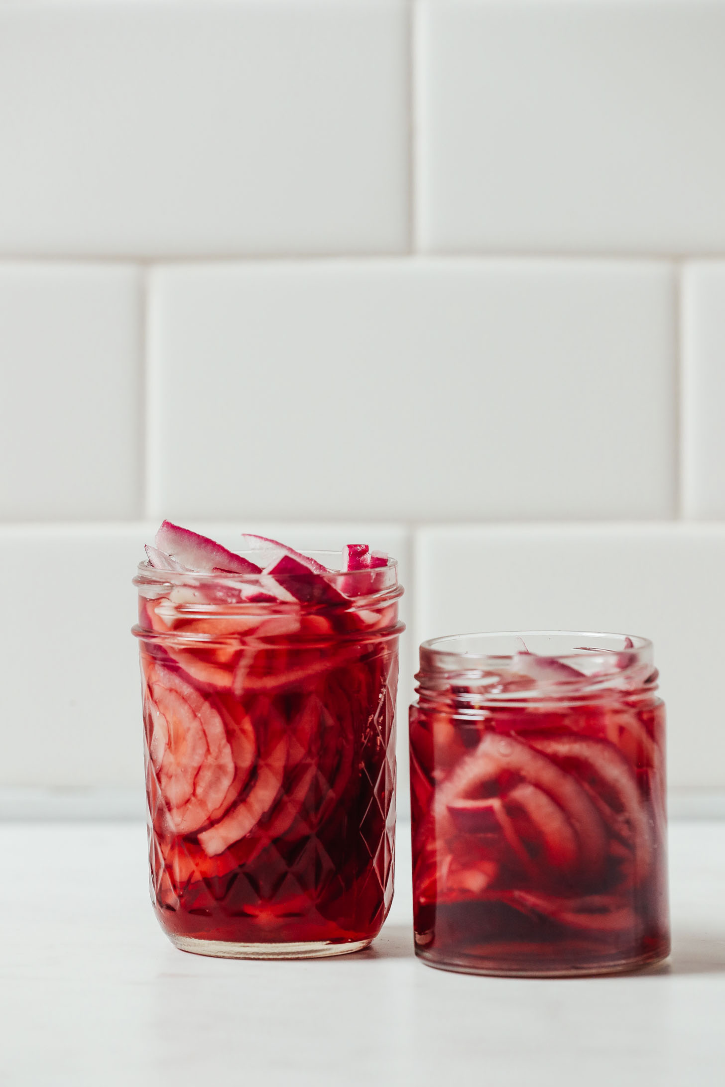 Two glass jars of our Quick Pickled Onions recipe