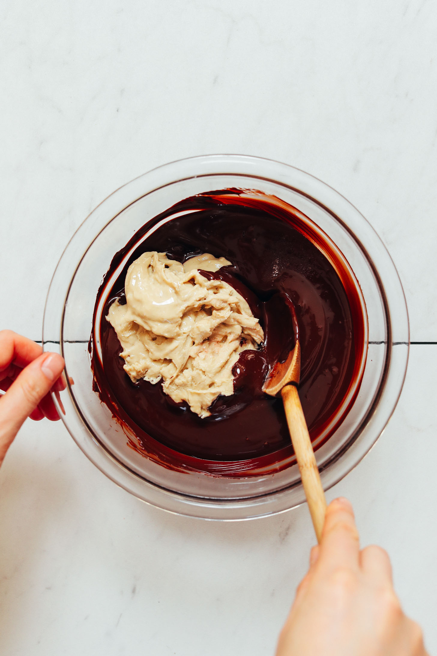 Cashew butter in a bowl of melted chocolate for making our 3-Ingredient Chocolate Fudge recipe