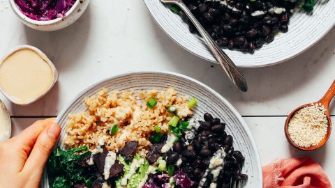 Holding the side of a Black Bean Buddha Bowl with Lemon Ginger Tahini Dressing