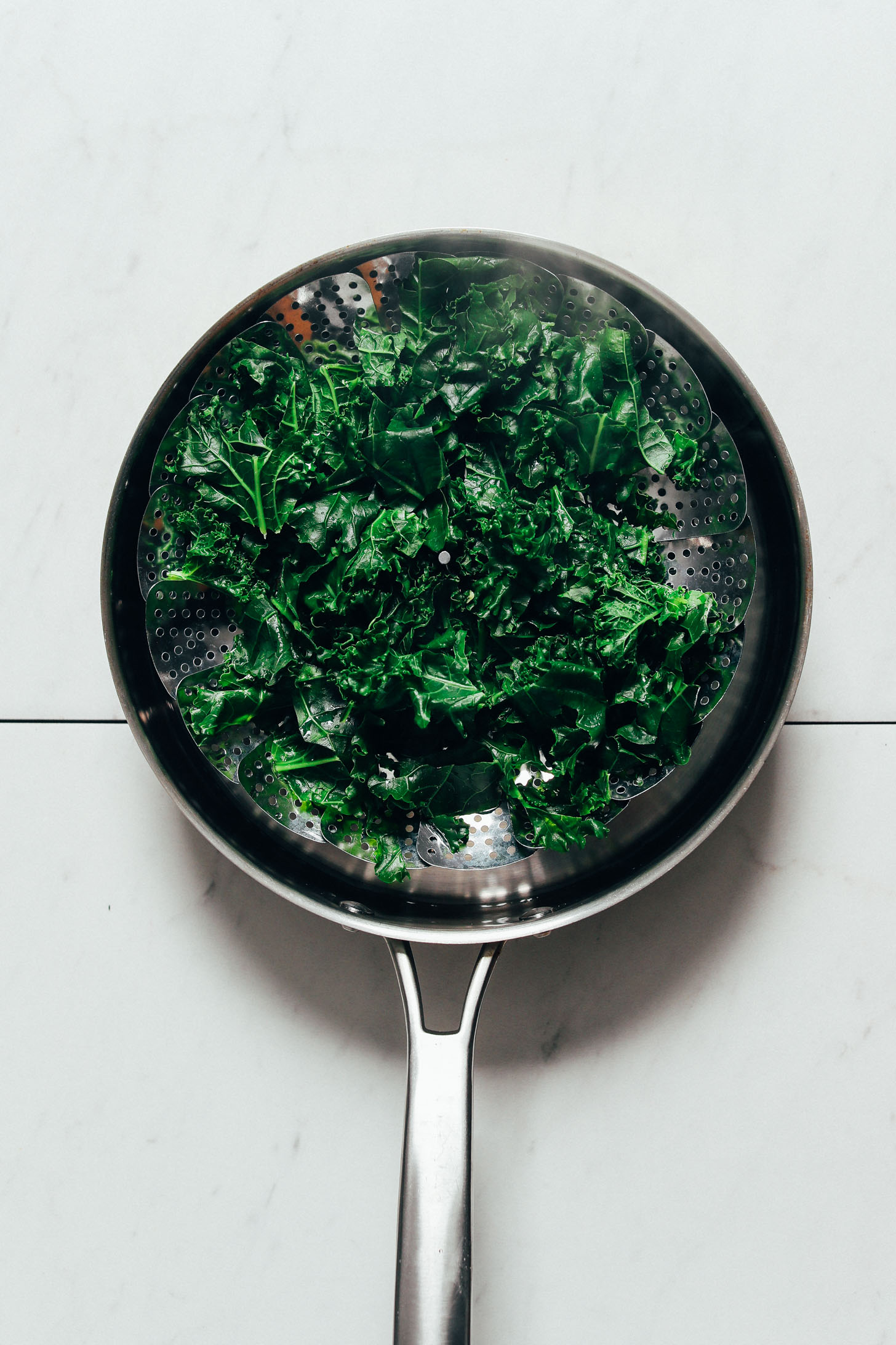 Pan of steamed kale for making Black Bean Buddha Bowls