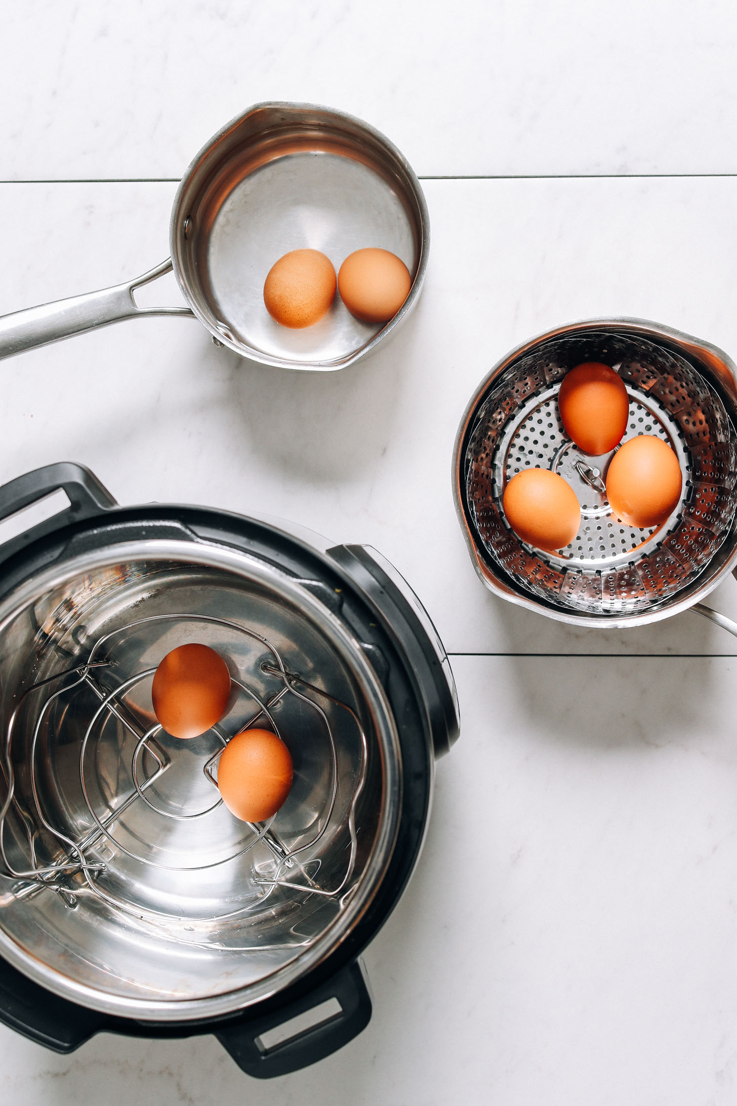 Hard boiled eggs in a steamer basket, saucepan, and instant pot for our post on how to make perfect hard boiled eggs