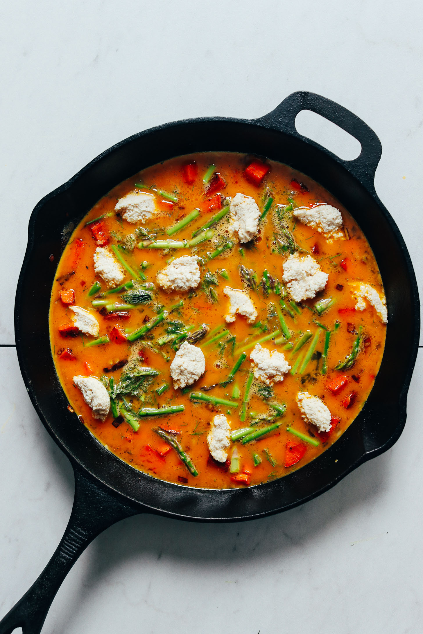 Skillet of uncooked Frittata with asparagus, nut cheese, and dill