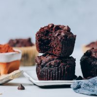 Tray with Banana Chocolate Muffins beside a spoonful of tahini and bowl of cocoa powder