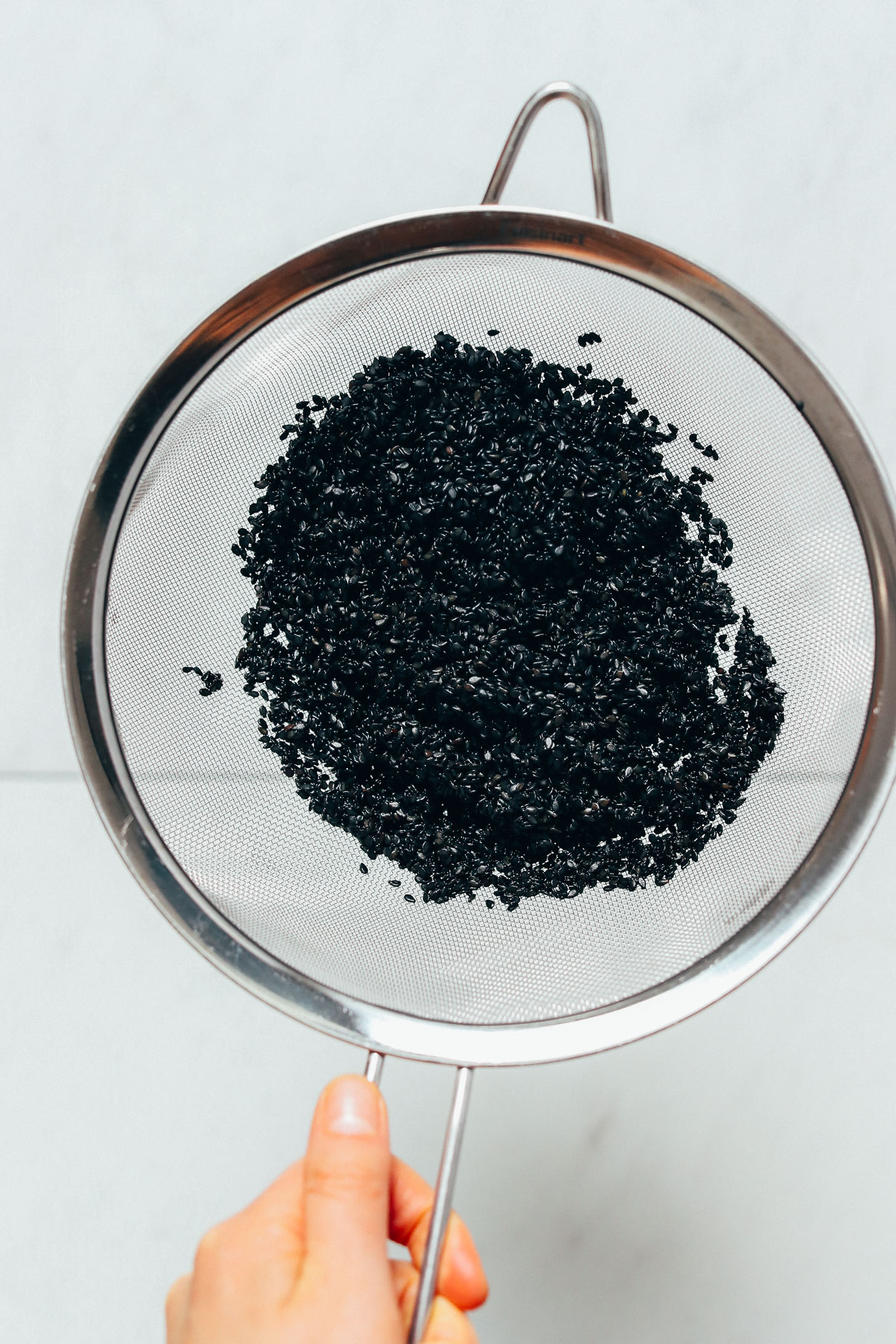Fine mesh strainer with rinsed black sesame seeds