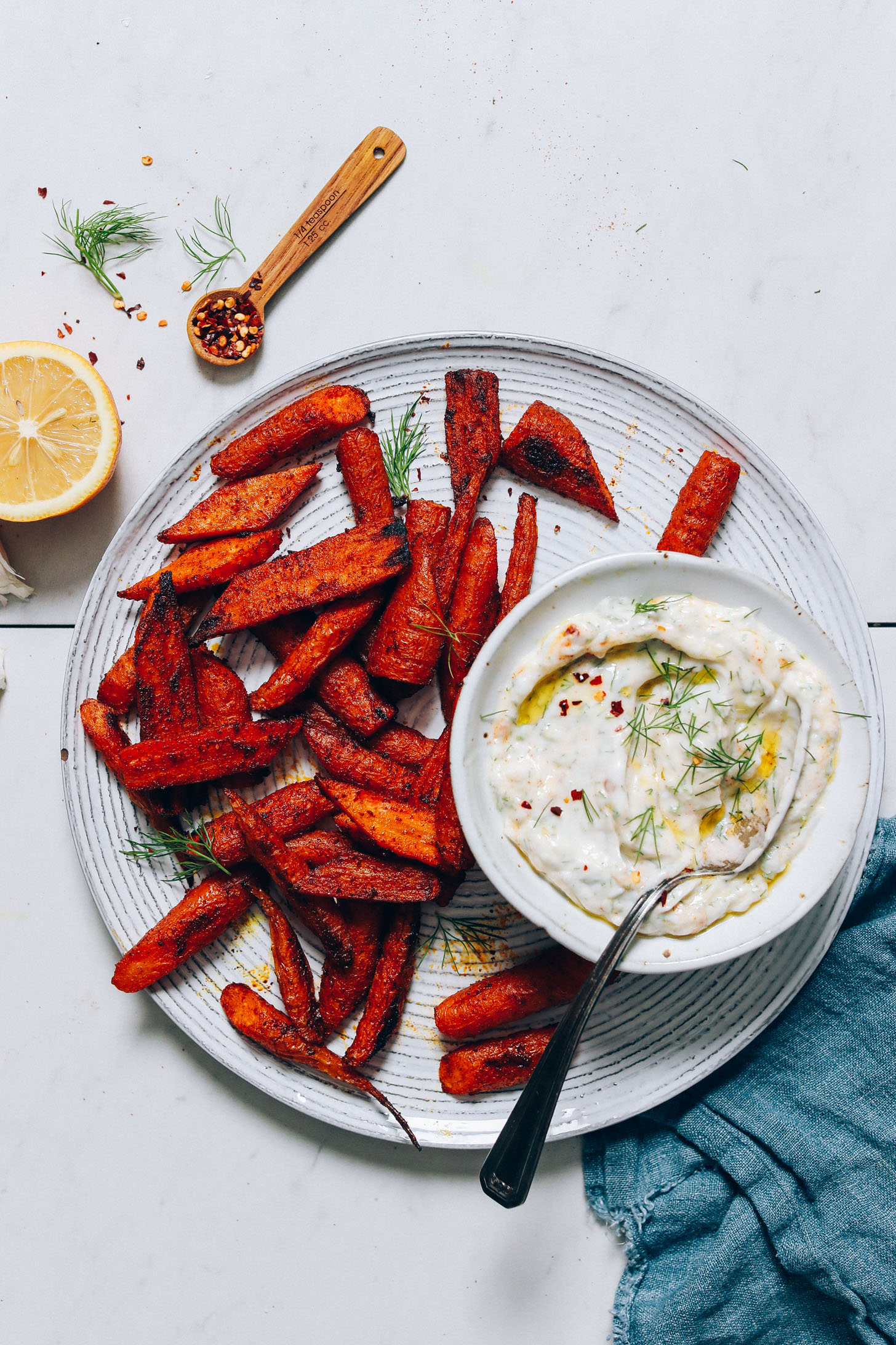 Perfectly roasted carrots coated in Moroccan spices beside a bowl of Dairy-Free Yogurt Dip