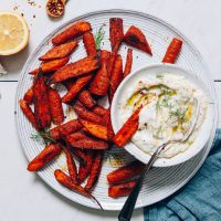 Bowl of Yogurt Sauce on a plate of Moroccan-Spiced Roasted Carrots