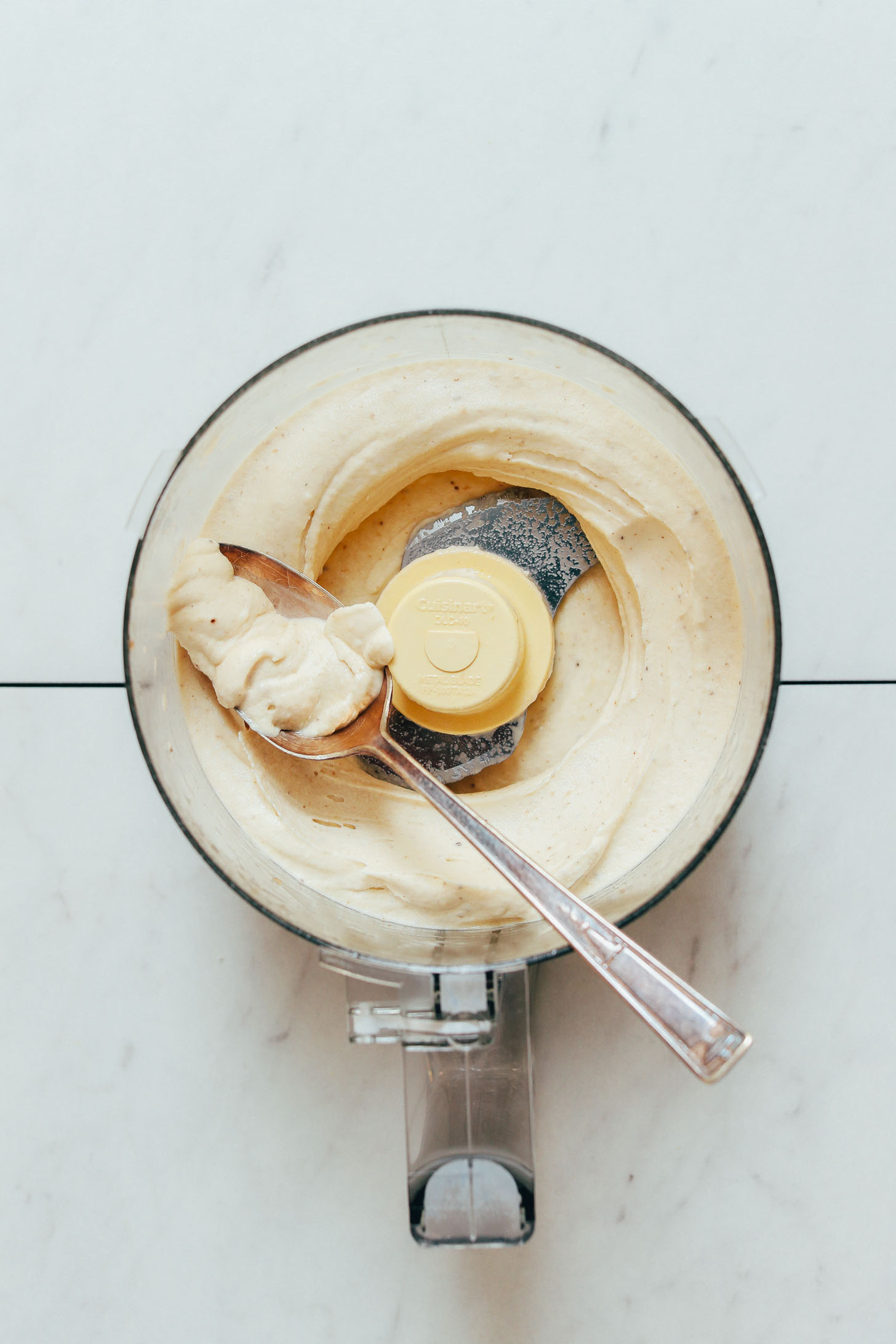 Spoon with a scoop of Banana Ice Cream in a food processor