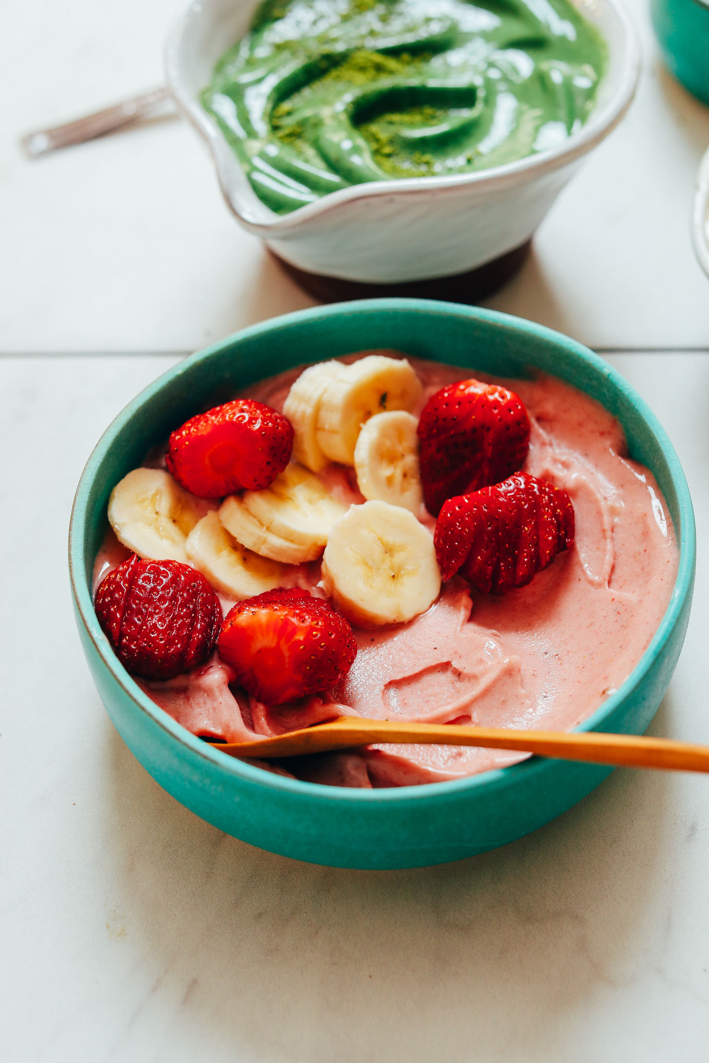 Bowl of strawberry banana ice cream with bananas and strawberries on top
