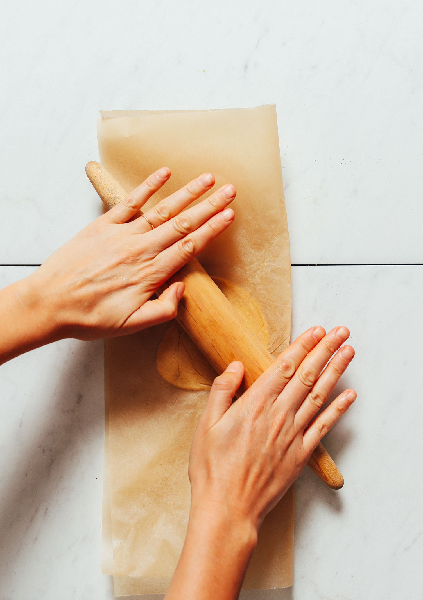 Using a rolling pin to roll out corn tortilla dough