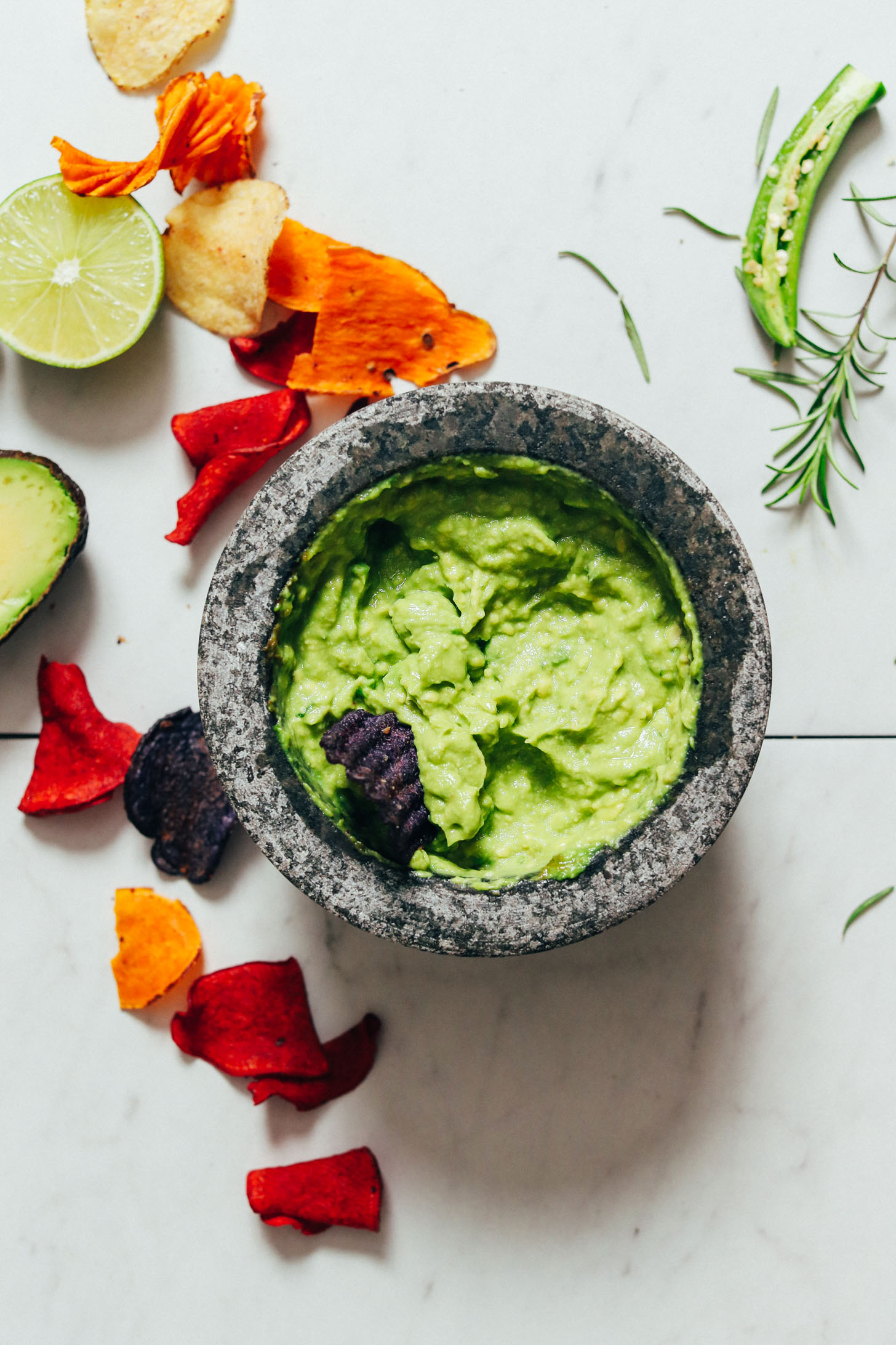 Veggie chips and a mortar and pestle of our Rosemary Guacamole recipe