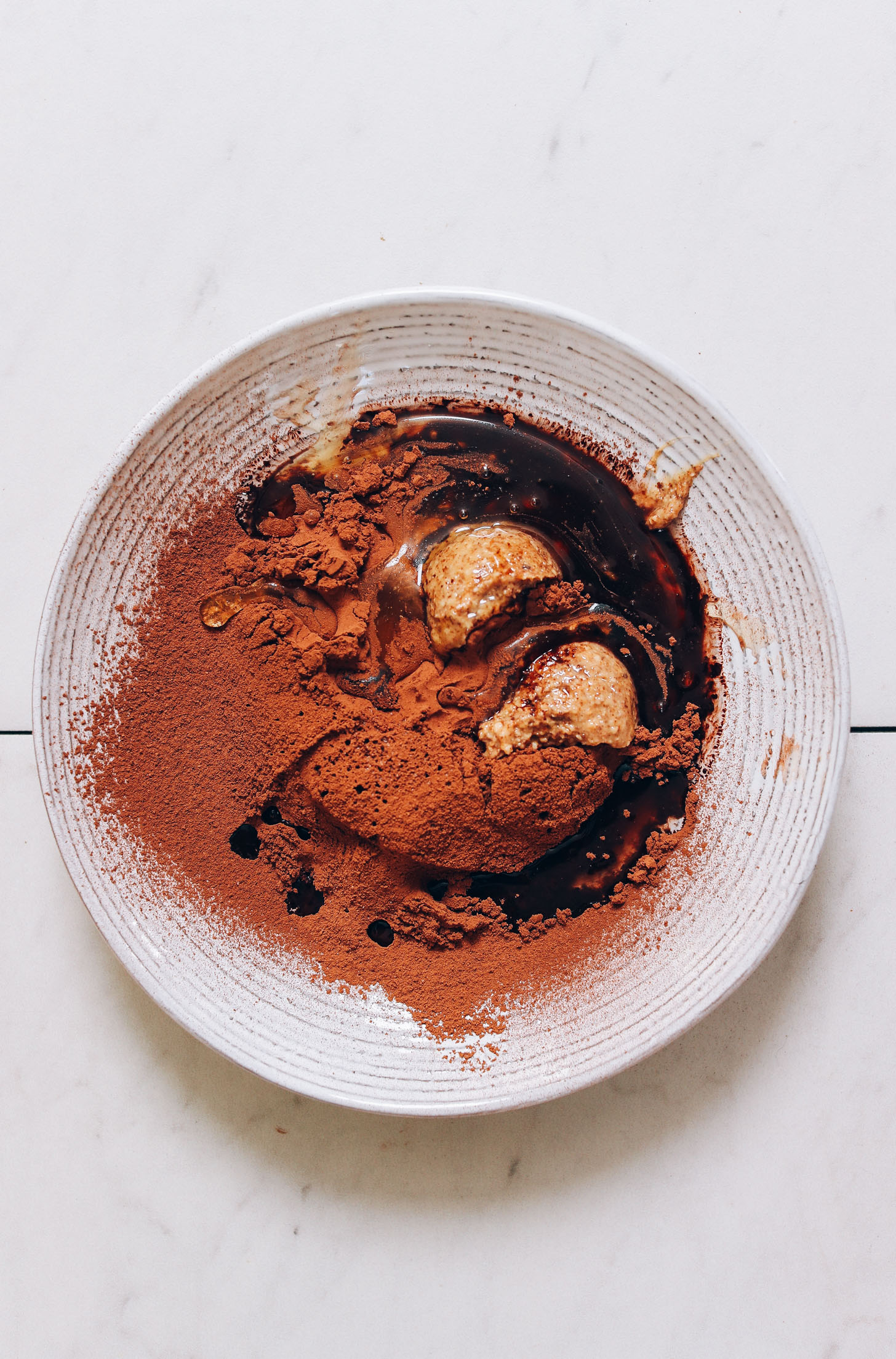 Bowl of honey, almond butter, and sifted cacao powder