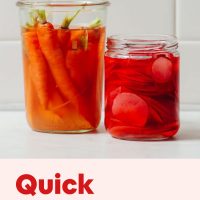 Jar of homemade Quick Pickled Radishes next to a jar of pickled carrots