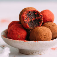 Bowl of No Bake Red Velvet Cake Balls coated in cacao powder and beet root powder