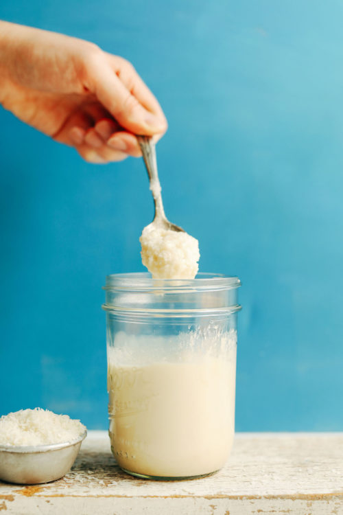 Holding a spoonful of coconut butter over a jar