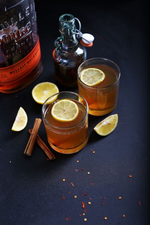 Two glasses of our Chili Cinnamon Hot Toddy recipe topped with lemon slices