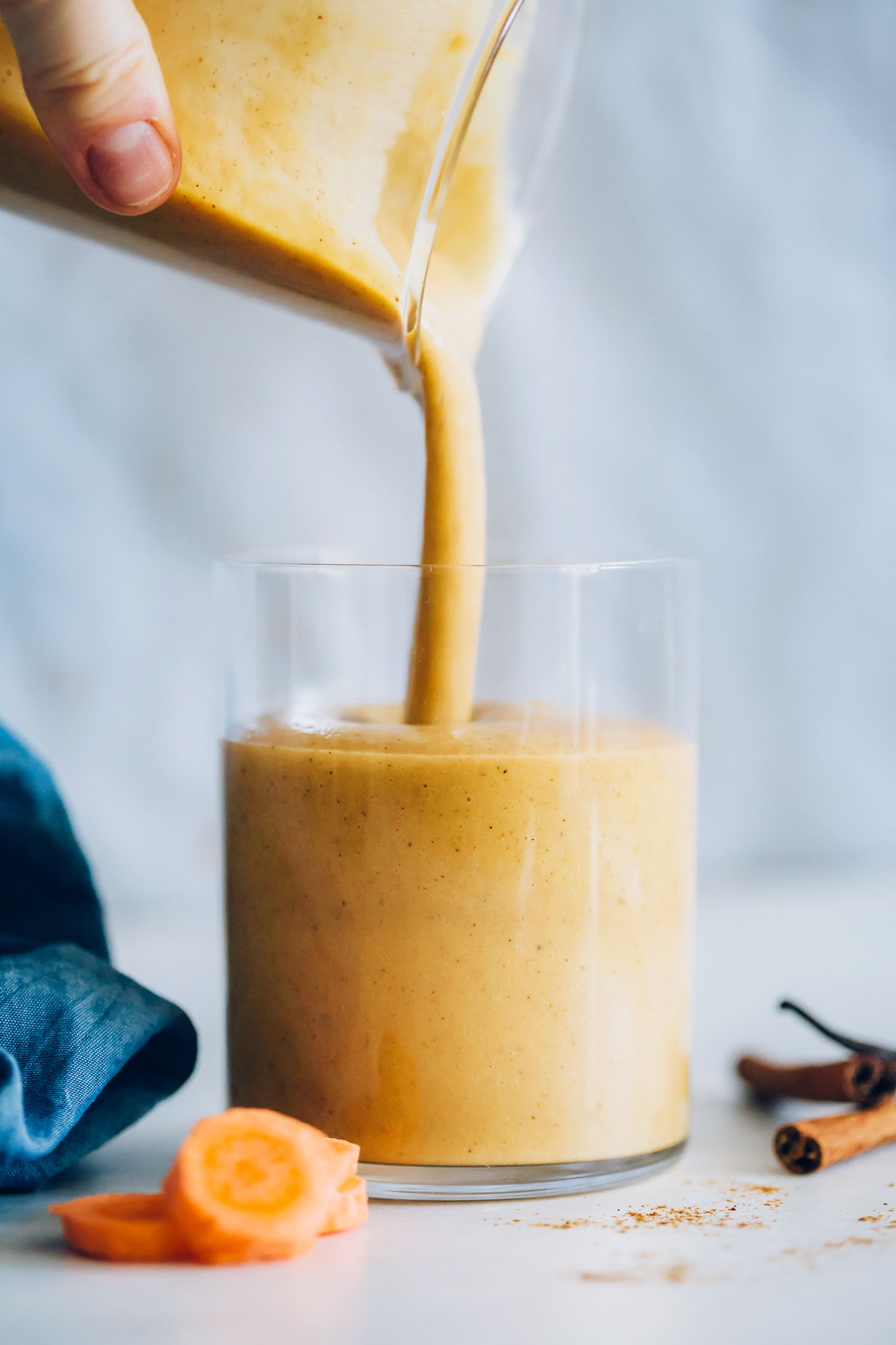 Pouring a pitcher of our Carrot Cake Smoothie into a glass